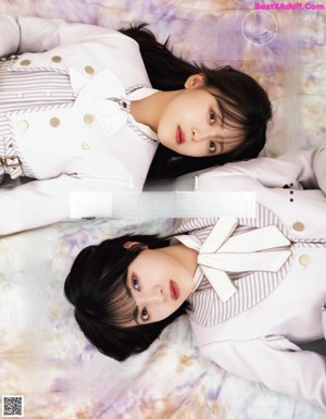 A magazine page with a picture of two girls laying on a bed.