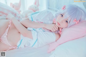 A woman sitting on a bed with her legs crossed.