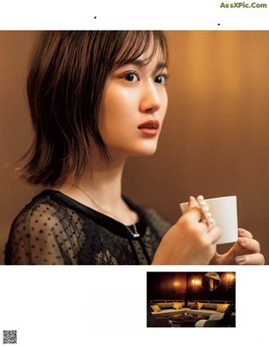 A woman in a black dress standing in front of a dining room.