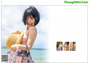 A woman sitting on the beach holding a pair of scissors.