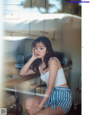 A woman in a white dress is posing for a magazine.