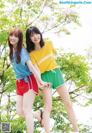 A couple of young women standing next to each other near a shopping cart.