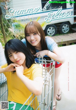 Two young women standing next to each other in front of a motel.