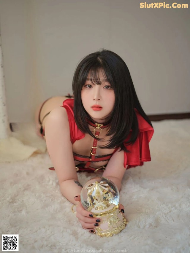 A woman laying on the floor holding a crystal ball.