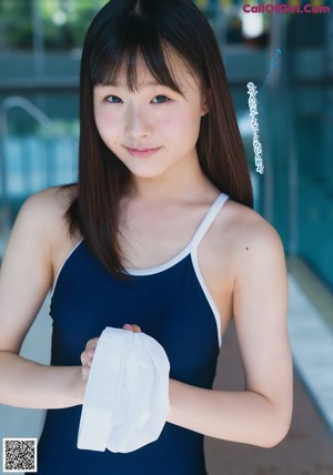 A young woman sitting at a table writing in a notebook.