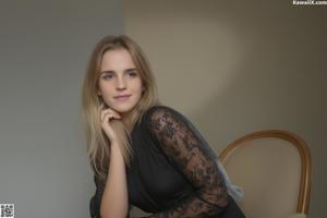 A young woman sitting on a couch holding a book.