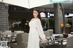 A woman in a white dress posing for a picture.