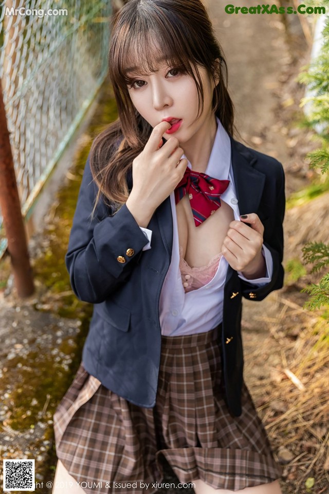 A woman in a school uniform posing for a picture.