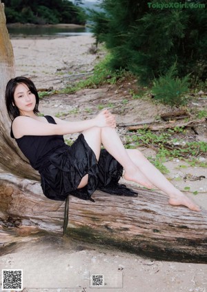 A woman in a white tank top posing for a magazine.