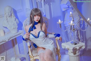 A woman sitting on a white chair in a room.