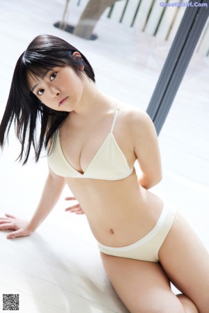 A woman in a white bikini posing for the camera.