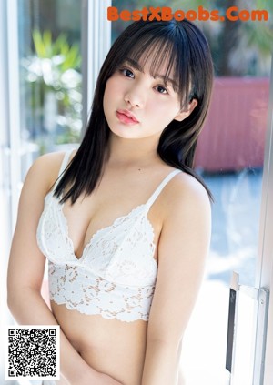 A woman in a white lingerie sitting on a blue couch.