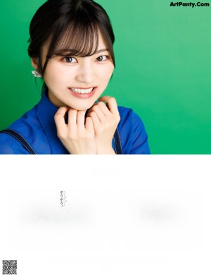 A woman in a blue shirt is posing for a picture.
