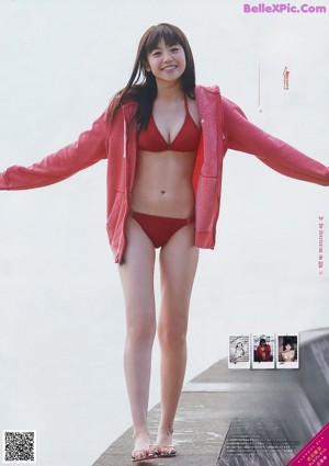 A woman in a white bikini and a knitted hat.
