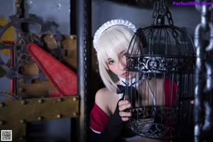 A woman in a maid outfit holding a chain.