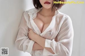A woman in a white shirt and black skirt posing for a picture.