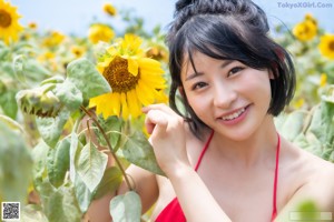 A woman in a sunflower field posing for a picture.