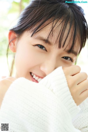 A woman in a white sweater posing for a picture.