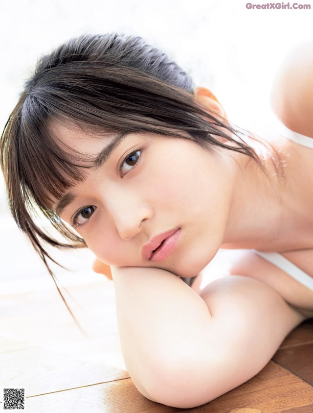 A woman laying on the floor with her hand on her chin.
