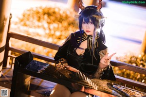 A woman dressed in a black and gold outfit posing for a picture.