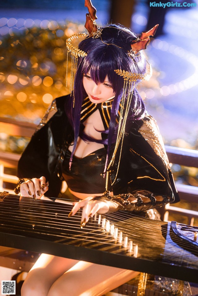 A woman in a black and gold outfit playing a musical instrument.