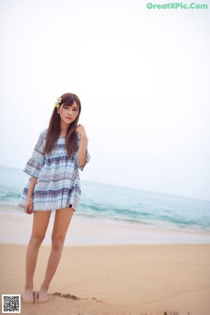 A woman in a bikini sitting on the beach.