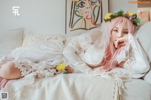 A woman in a wedding dress sitting on a window sill.