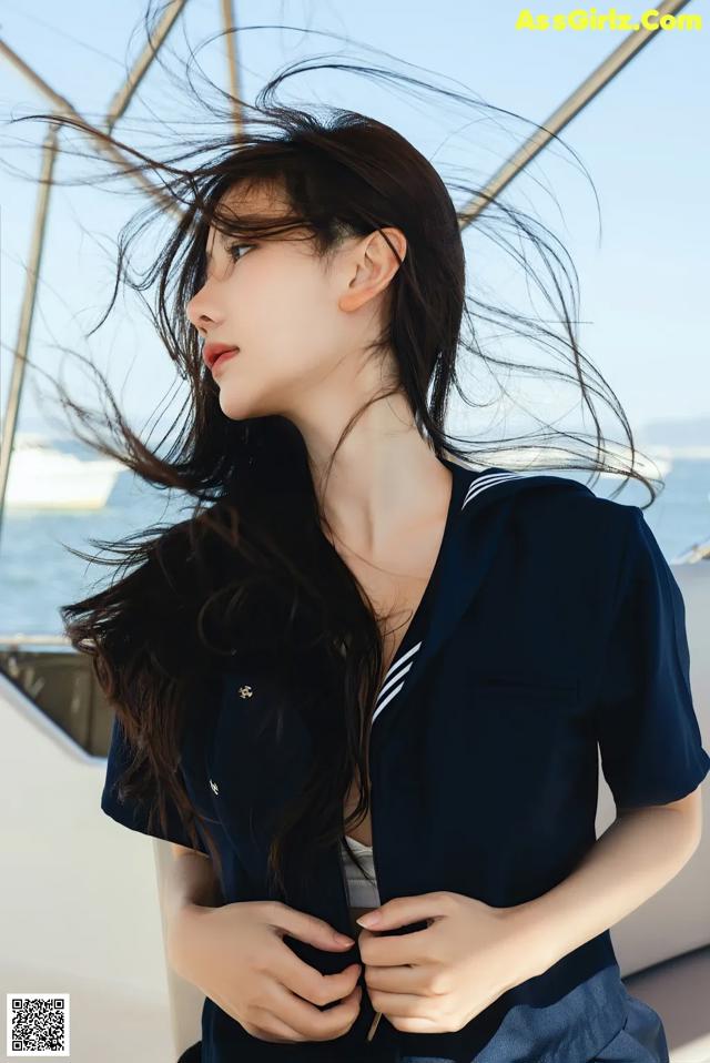 A woman in a sailor outfit standing on a boat.