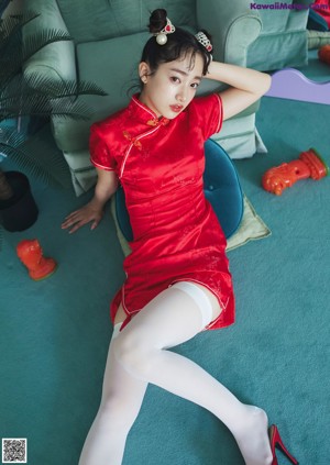 A woman sitting on top of a bed next to a teddy bear.