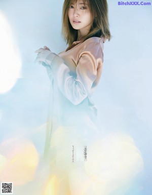 A woman in a blue sweater and skirt posing for a magazine.