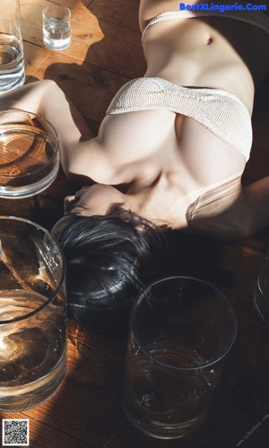 A woman laying on top of a bed next to a pillow.