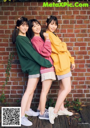 A group of young women posing in front of a window.