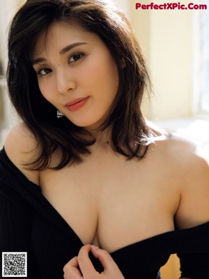 A woman in a green dress sitting on a white chair.