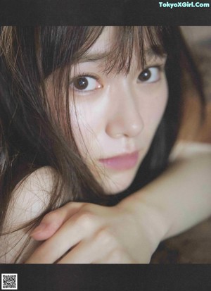 A woman with long brown hair is posing for a picture.
