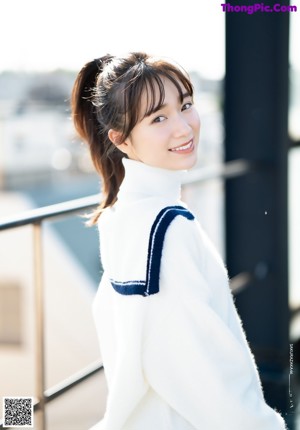 A woman with long brown hair smiling at the camera.