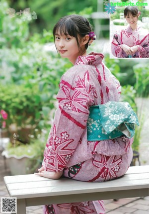A young woman in a school uniform with a towel over her head.
