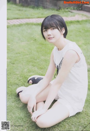 A woman in a white dress laying on the grass.