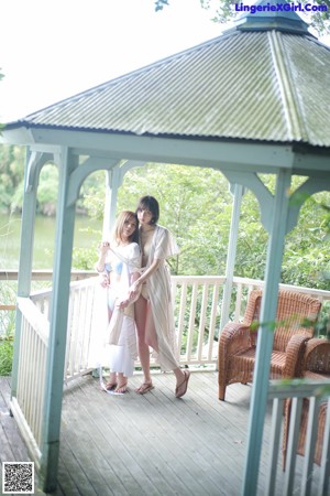 A couple of women standing next to each other on a balcony.