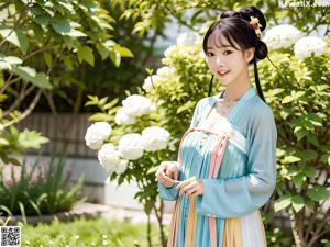 A woman in a pink and blue dress standing in a garden.